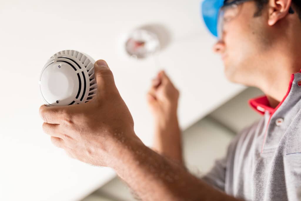 Man installing smoke detector smoke alarm