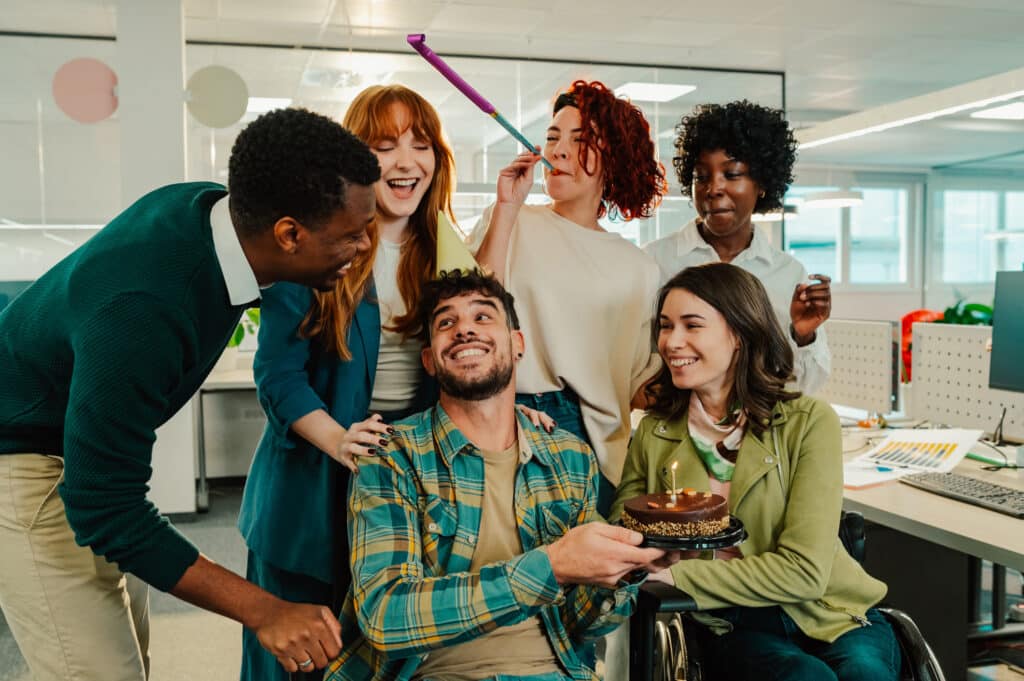 A diverse team celebrating a birthday at the office.